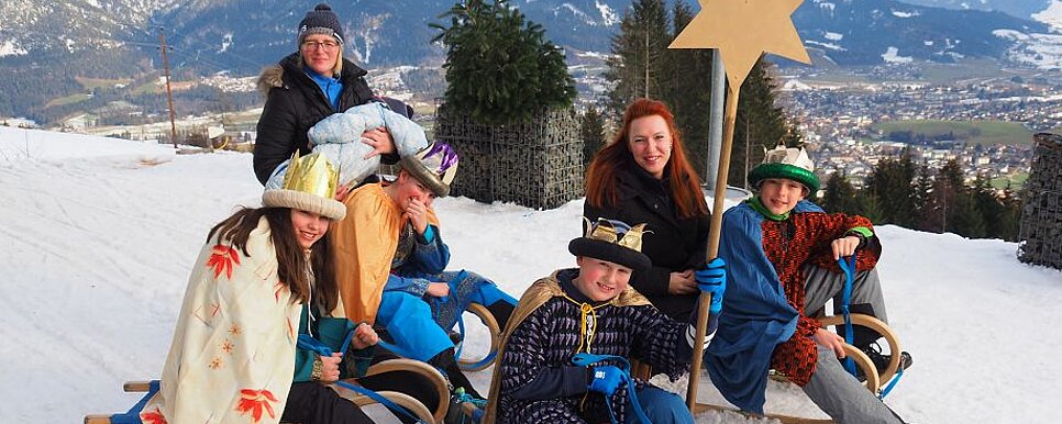 Sternsingergruppe mit Schlitten im Schnee