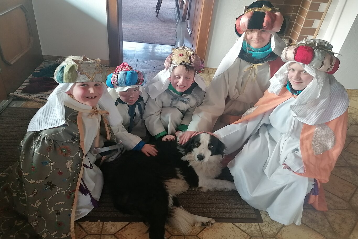 Sternsingergruppe aus Oberndorf in Tirol streichelt einen Hund