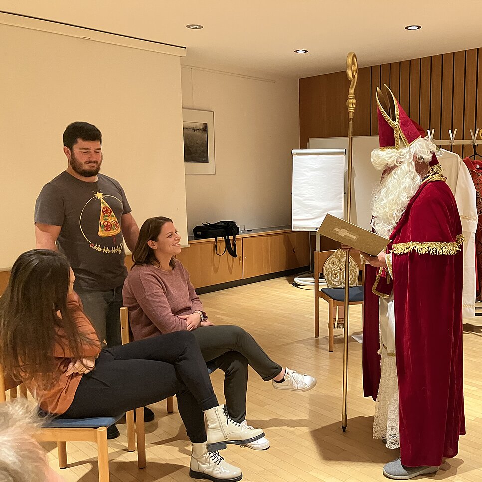 Ein Nikolausdarsteller übt seinen Auftritt vor anderen Teilnehmer:innen der Nikolausschule.
